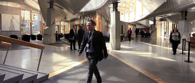 The Garden Lobby in the Scottish Parliament. It's busy and staff and MSPs are walking around.