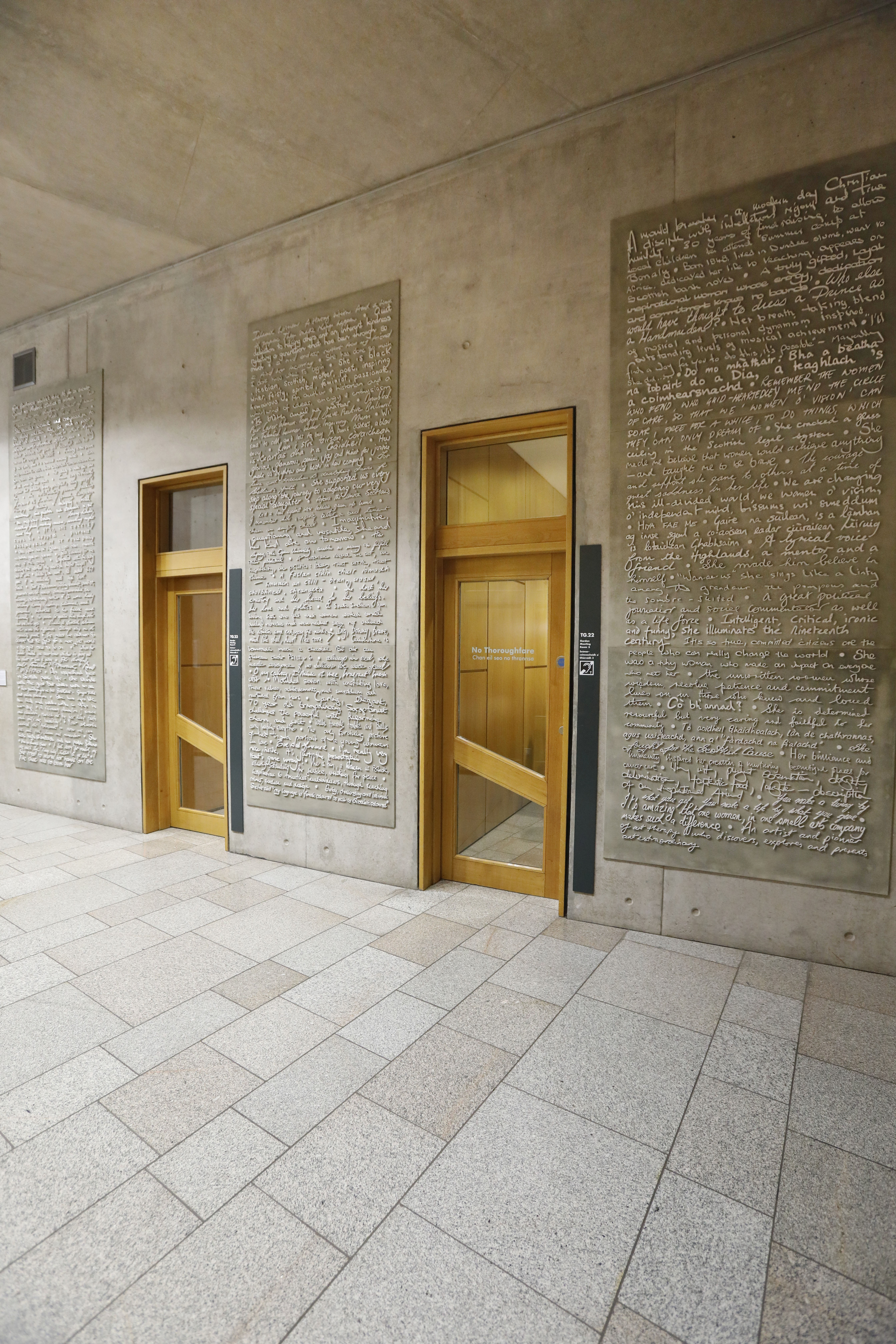 Very large installation on three walls, filling from ceiling to floor, of 100 white porcelain handwritten sentences.